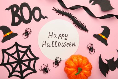 Cadılar Bayramı kompozisyonu, pembe pastel arka planda örümcekler ve yarasalar. Üst görünüm