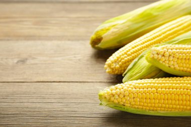 Kırsal ahşap masadaki koçanlarda taze mısır, yakın plan. Üst görünüm