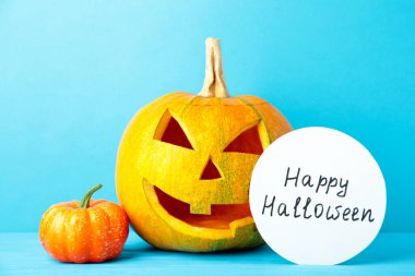 Süslü Cadılar Bayramı Balkabağı. Mavi arka planda Korkunç Jack. Üst görünüm