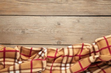 Gri ahşap arka planda kareli ekose. Üst görünüm