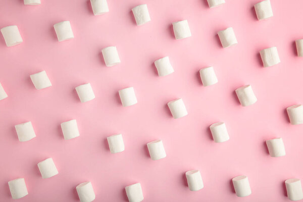 White marshmallows on a pink background. Top view