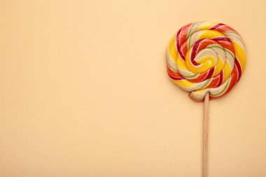 Bej arka planda çok renkli lolipop, yukarıdan görünüm.