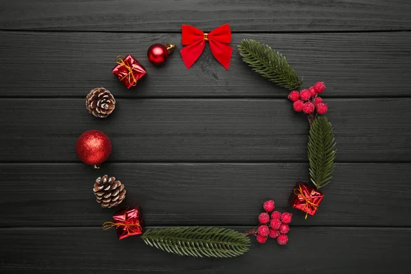 Christmas wreath on black wooden background. Christmas composition. Top view, copy space.