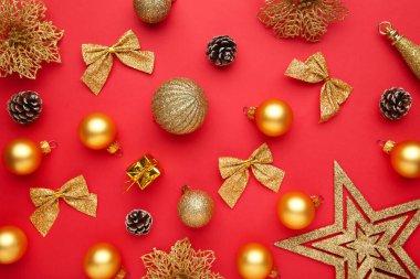 Kırmızı arka planda noel altın süslemesinden yapılmış Noel kompozisyonu. Düz yatış, üst görünüm.