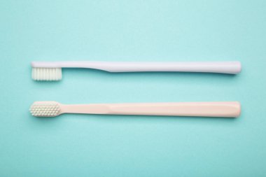 Açık mavi arka planda patel diş fırçaları. Diş sağlığı ve hijyen konsepti. Üst görünüm