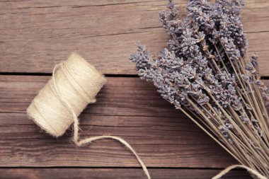 Gri ahşap arka planda kırsal sicimle kurutulmuş lavanta demeti. Üst görünüm