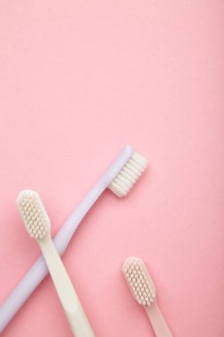 Patel diş fırçaları pembe arka planda. Diş sağlığı ve hijyen konsepti. Üst görünüm