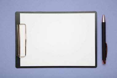 Mor arka planda kağıt olan kalem ve siyah pano. Üst görünüm