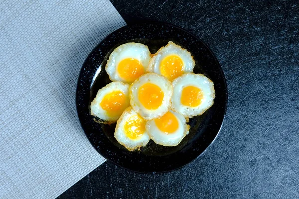 Fried quail egg on black background — Stock Photo, Image