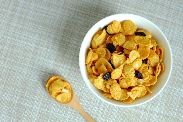 Corn flakes in white bowl on texture background