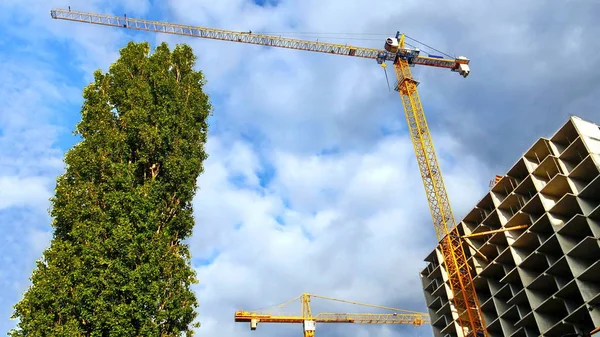 İnşaat vinci inşaat halindeki mavi gökyüzüne karşı. İnşaat alanı.