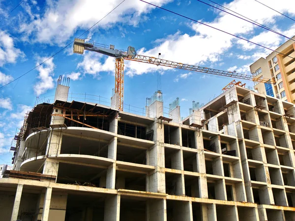 İnşaat vinci inşaat halindeki mavi gökyüzüne karşı. İnşaat alanı.