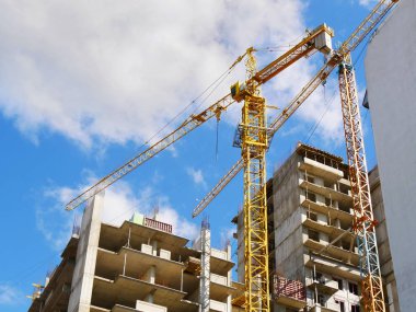 Binanın yanında iki vinç var. İnşaat devam ediyor. İnşaat alanı.