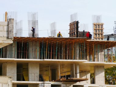 İşçiler bir bina dikerler. İnşaat alanı. Bina yapım aşamasında. 