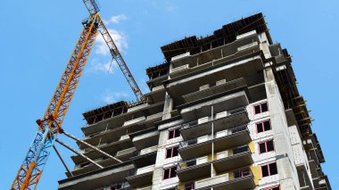 İnşaat alanı. Binanın yakınındaki endüstriyel vinç. Bina yapım aşamasında.