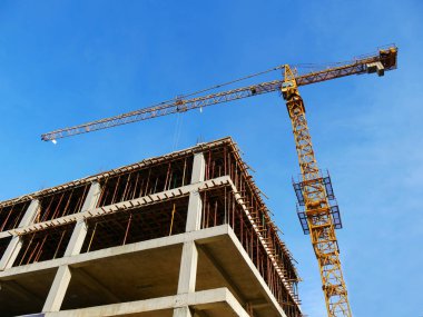 Vinç ve inşaat altında beton bina. Şantiye arka planı