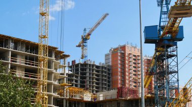 Şantiye arka plan. İnşaat binaları yakınındaki vinçler. Ticari inşaat projesi