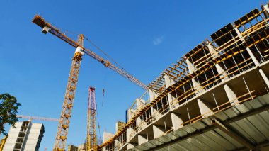 İnşaat alanında. Beton bina yakınındaki vinç.
