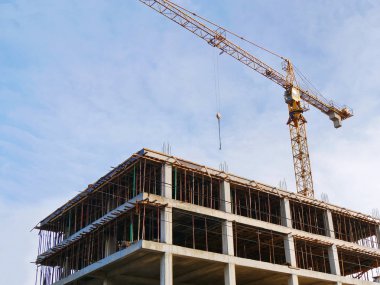 İnşaat alanında. Vinç ve mavi gökyüzü karşı bina beton.