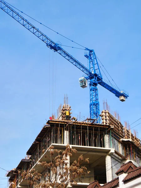 Construction site background. Construction crane and building against blue sky