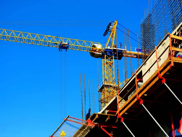 Construction site background. Crane and building against blue sky
