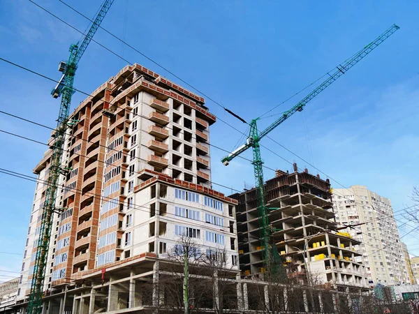 Construction site background. Commerxial construction project. Two cranes near building under construction