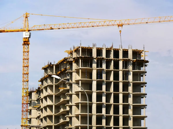 Construction site background. Concrete building and crane under construction