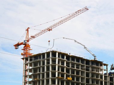 Gökdelen inşaat. Daralma altında beton bina yakınındaki vinç. İnşaat alanı.