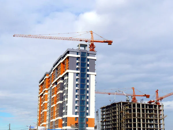 Construction site. background. Three  cranes near buildings under construction.