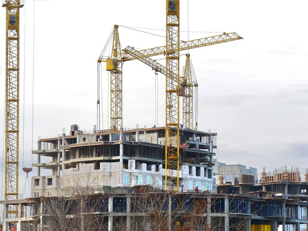 Construction site. Tower crane near concrete building. Four tower cranes near concrete building.