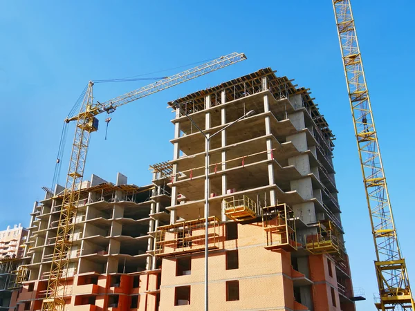 Vinç ve beton bina ile şantiye. İnşaat alanında. Building yakınındaki iki Vinçler.