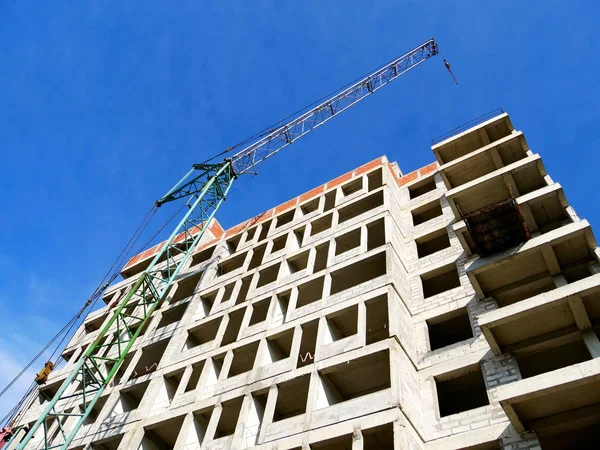 Construction site. Crane and building against blue sky. Building site.