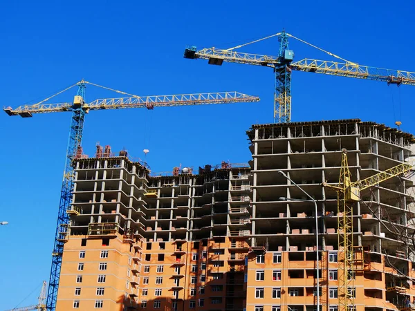 Construction of a multi-storey building. Three cranes near build Royalty Free Stock Images