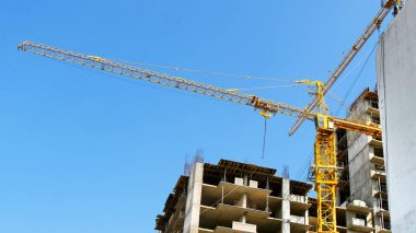 Binanın yanında büyük bir vinç. İki vinç ve inşaat faaliyeti. Eksi -lerini