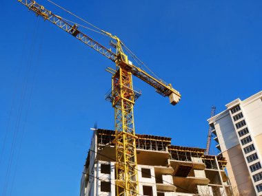 Binanın yanında büyük bir vinç. İnşaat aşamasındaki beton bina. 