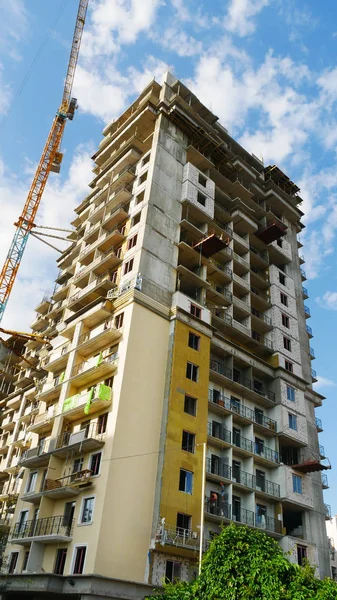 Byggandet av en skyskrapa. Två kranar i närheten av byggnaden — Stockfoto