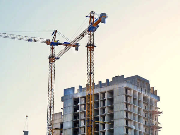 Twee kranen in de buurt van gebouw. Beton gebouw in aanbouw. — Stockfoto