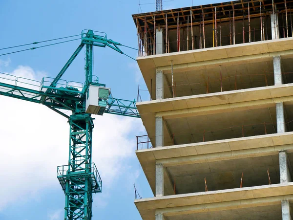 Historia de la construcción. Las grúas anfitrionas y el nuevo edificio de varias plantas. — Foto de Stock