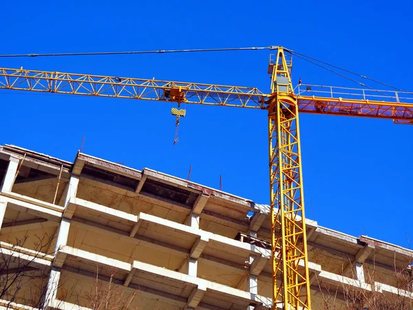 Tower crane and building activity. Construction site background.