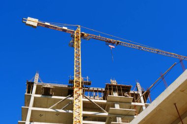 İnşaat alanı. Yüksek katlı çok katlı binalar yapım aşamasında. Binanın yakınındaki kule vinci.