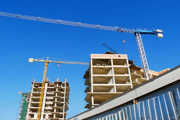 İnşaat alanı. İnşaat altında yüksek katlı çok katlıdır. Binaların yakınındaki kule vinçler. 