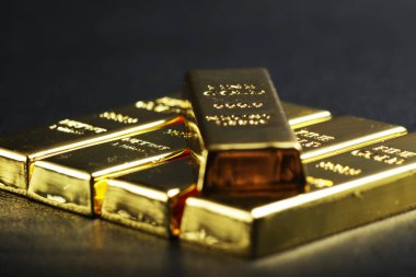 close up shot of stacked 999.9 pure gold bar ingot on a black background, represented the business, invesment and finance concept idea