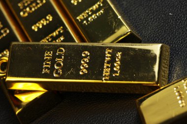 close up shot of stacked 999.9 pure gold bar ingot on a black background, represented the business, invesment and finance concept idea