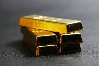 close up shot of stacked 999.9 pure gold bar ingot on a black background, represented the business, invesment and finance concept idea