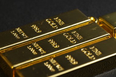 close up shot of stacked 999.9 pure gold bar ingot on a black background, represented the business, invesment and finance concept idea