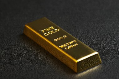 close up shot of stacked 999.9 pure gold bar ingot on a black background, represented the business, invesment and finance concept idea
