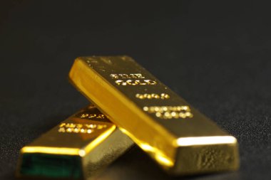 close up shot of stacked 999.9 pure gold bar ingot on a black background, represented the business, invesment and finance concept idea