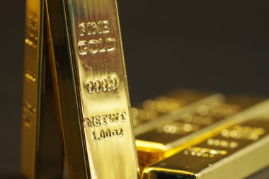close up shot of stacked 999.9 pure gold bar ingot on a black background, represented the business, invesment and finance concept idea