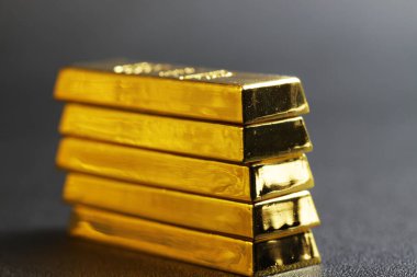 close up shot of stacked 999.9 pure gold bar ingot on a black background, represented the business, invesment and finance concept idea