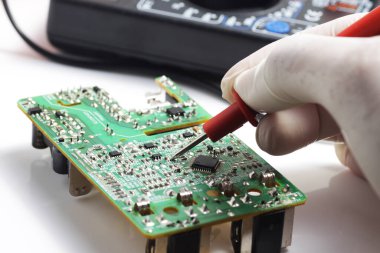 Elektronik eşyalar tamir edilirken çoklu test cihazı kullanılarak SMD bileşeni test ediliyor